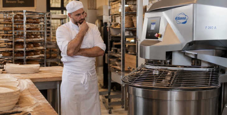 Bäckereihandwerk-nachdenklicher-bäcker-neben-industriemixer